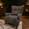 Howarth Leopard Armchair upholstered in Wild 235 luxury woven leopard fabric with a high wingback design and solid wood legs at Amadi Home
